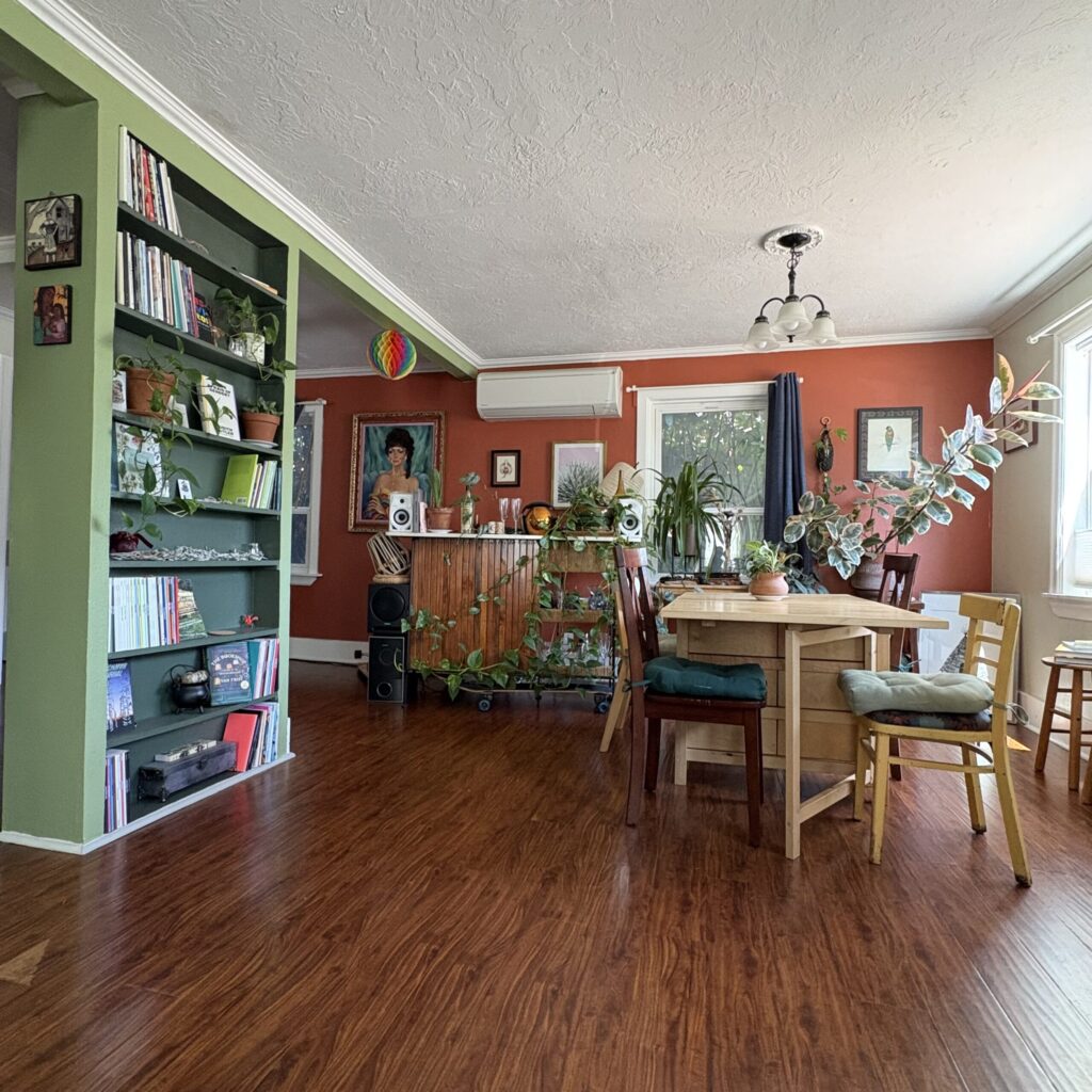 A table, DJ booth / bar, and poetry shelves at The Farmhouse.