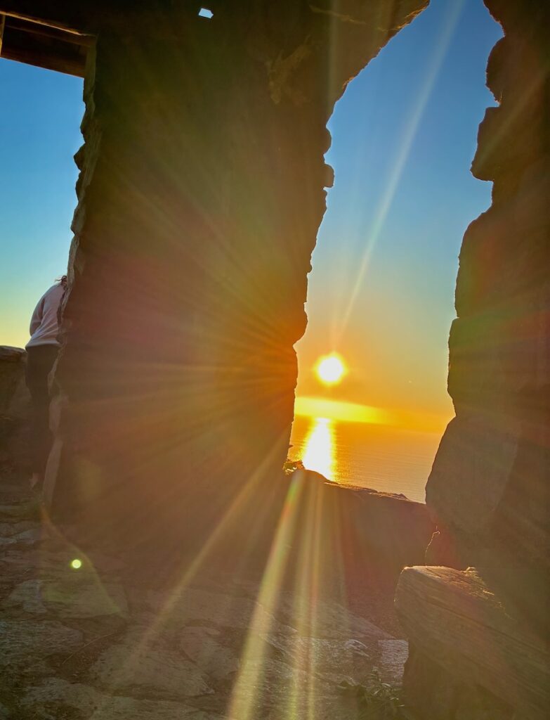 The setting sun streaming through an opening in the Cape Perpetual lookout.